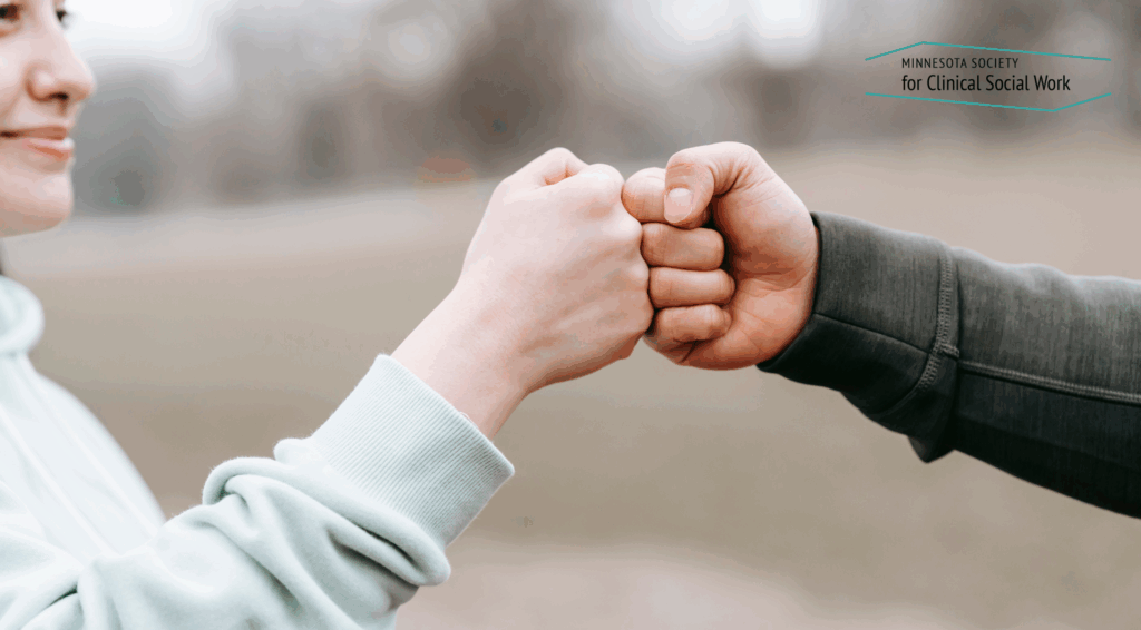 two people fist bumping - pushing their closed fists together.